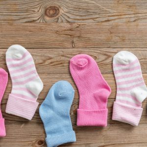 Baby boy and girl socks on wooden background