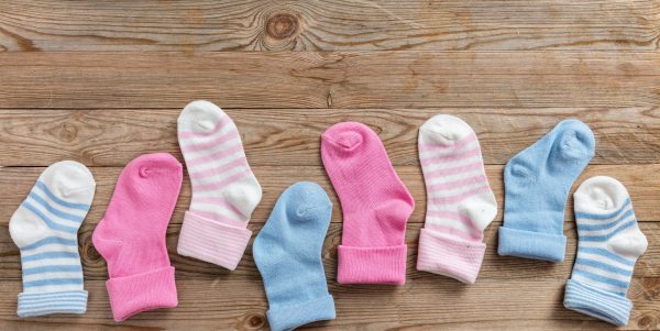 Baby boy and girl socks on wooden background