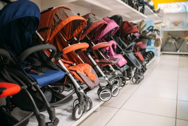 Row of baby strollers on shelf in store, nobody